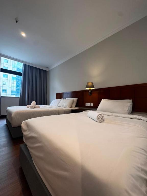 a hotel room with two beds and a window at Kingston Hotel 21 - JO Hotel Johor Bahru in Johor Bahru