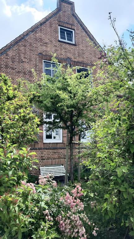 a brick house with a bench in front of a tree at Altbauvilla nahe Schlosspark in Eutin