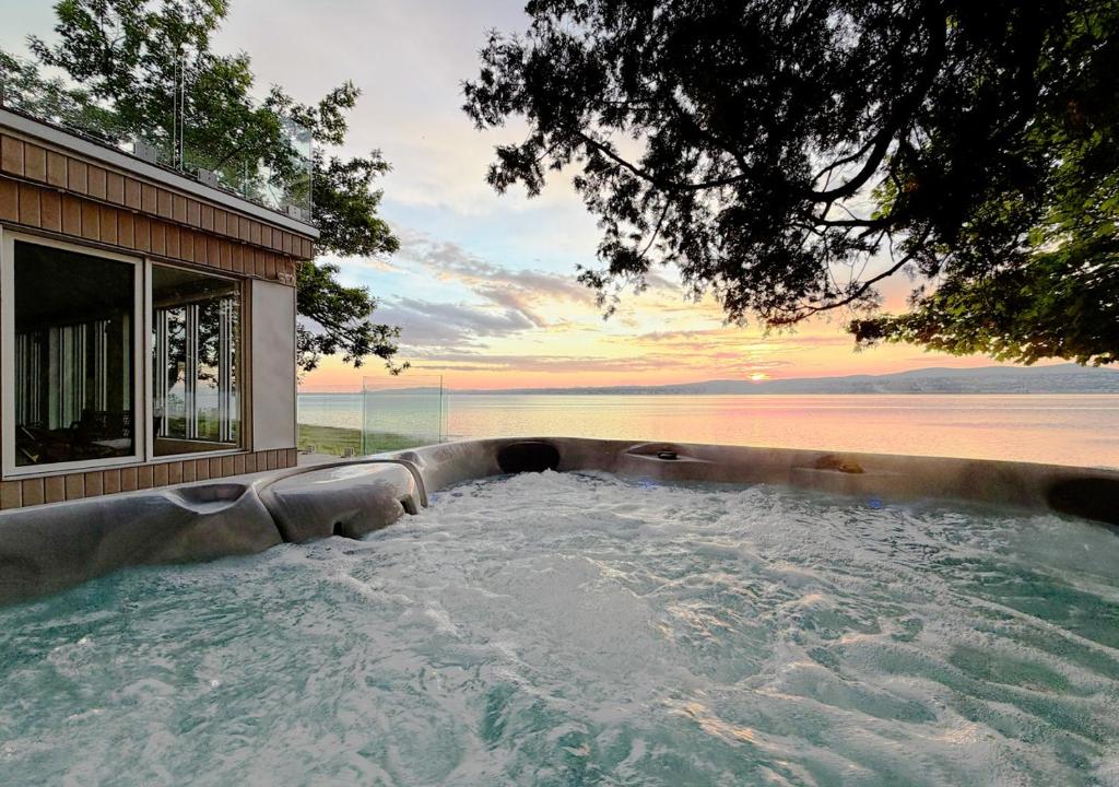 a hot tub with a view of the ocean at VILLA-29 Spa, Sauna, Sunset & Waterfront View in Sainte-Petronille