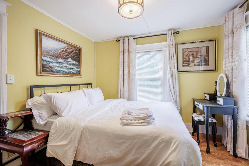 a bedroom with a white bed with a desk and a window at Room B5 Shared bathroom queen Bed Washer Dryer in Rochester