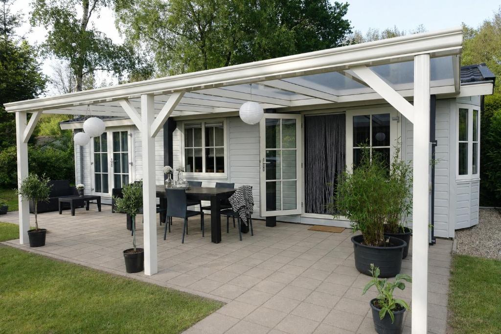 a pavilion with a table and chairs on a patio at Vechtdalchalet de Berk, 5 sterrenpark Capfun Stoetenslagh in Rheezerveen