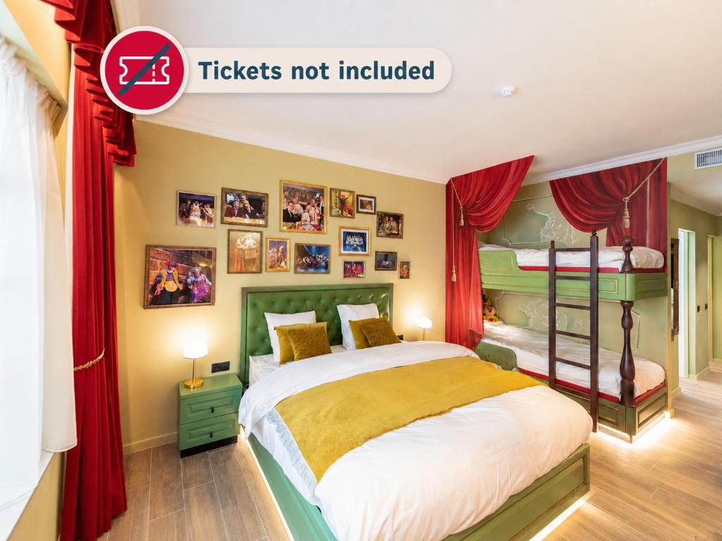 a bedroom with a bed with red curtains at Plopsaland Theater Hotel in De Panne