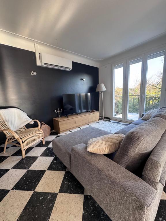 a living room with a couch and a tv at Maison rénovée Montélimar in Montélimar