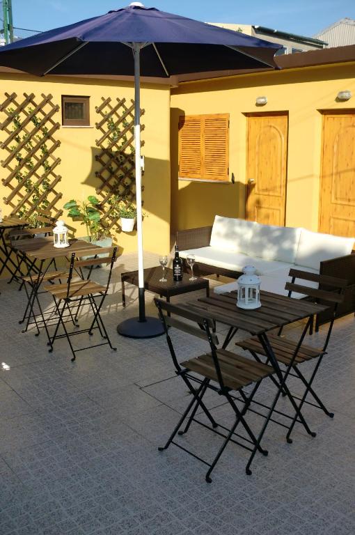 two tables and chairs with an umbrella on a patio at The Yellow House 2 in Porto