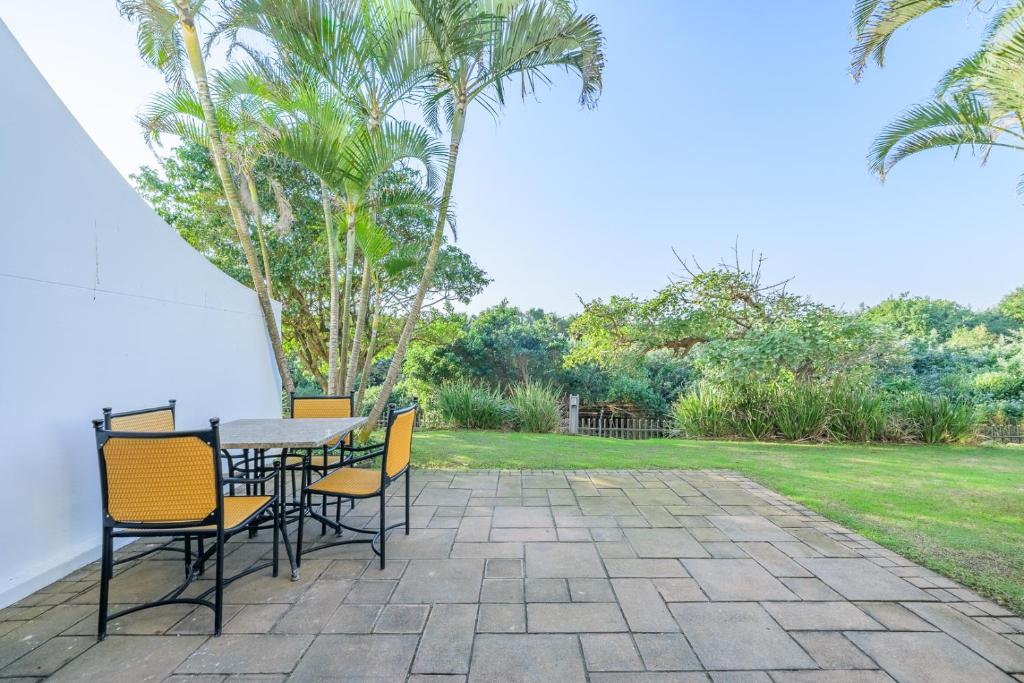 a table and chairs sitting on a patio at Breakers Resort 130 Umhlanga Beachfront in Durban