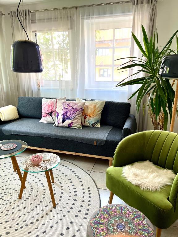 a living room with a blue couch and two chairs at Lichte Wohnung zum Wohlfühlen in Bastheim