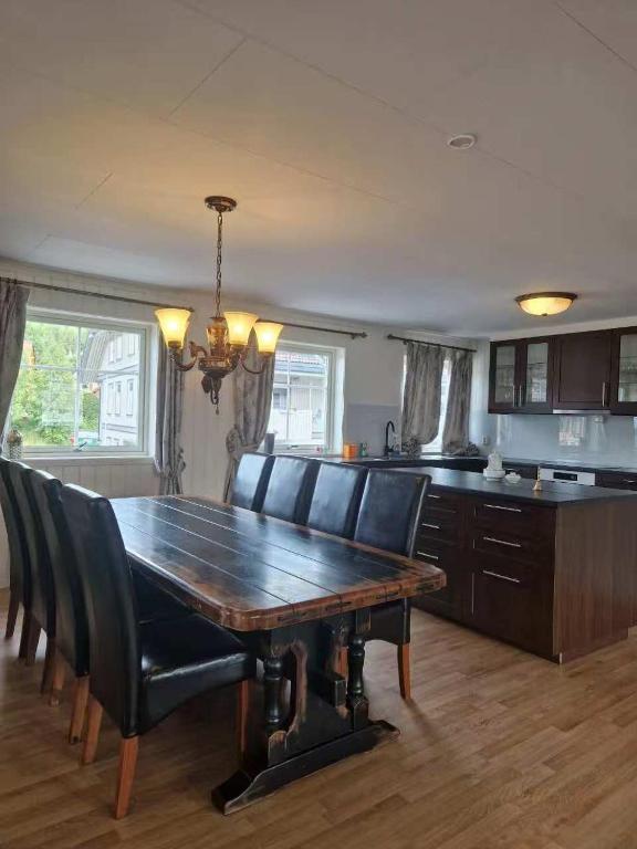 a dining room table with chairs and a kitchen at Trysil sentrum apartment in Trysil