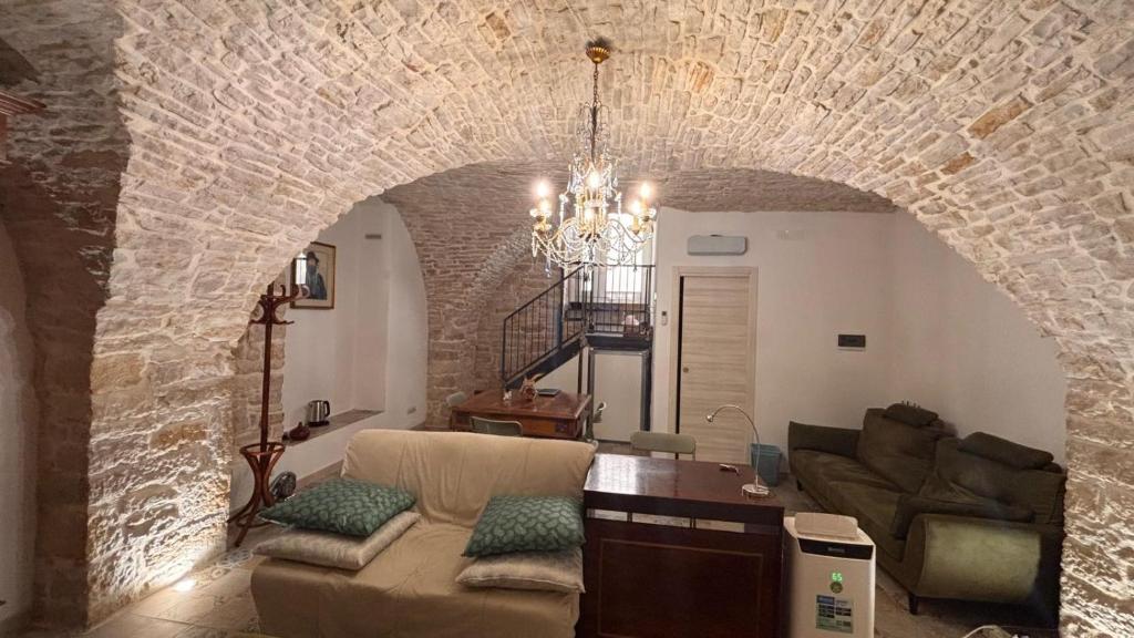 a living room with a couch and a stone wall at Appartamento San Giorgio in Bitonto