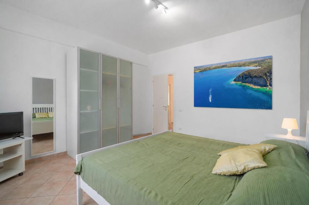 a bedroom with a green bed and a television at Excelsior - Venturina Terme in Venturina Terme