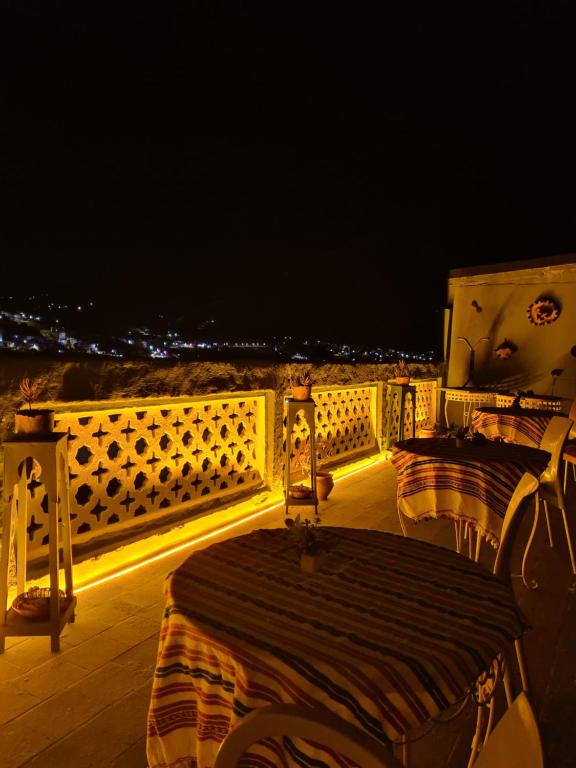 a table and chairs on a balcony at night at La Joya Hostel Chafchaouen Cozy Stay with Terrace in Chefchaouen