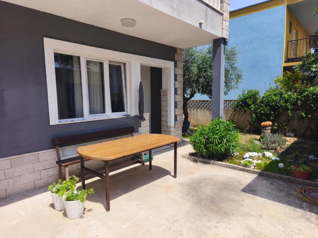 a wooden table sitting outside of a house at Ora Apartment in Kastel Sucurac
