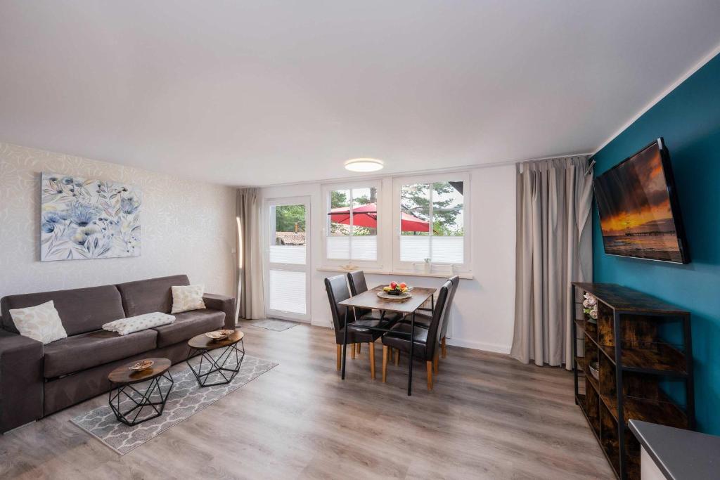 a living room with a couch and a table at Waldsiedlung Waldhaus App 2.2 in Korswandt