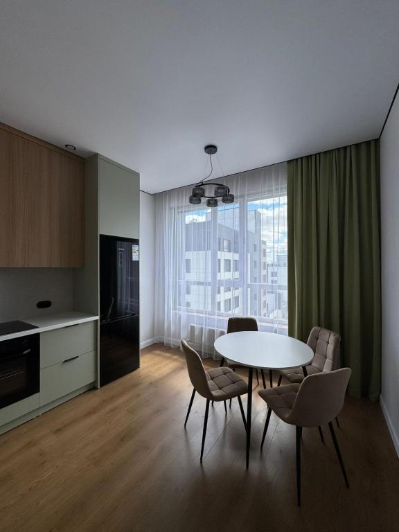 a kitchen and dining room with a table and chairs at NewCityLife in Astana