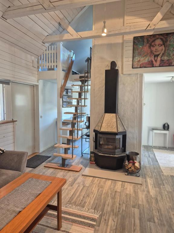 a living room with a fireplace and a staircase at lillstugan in Avesta