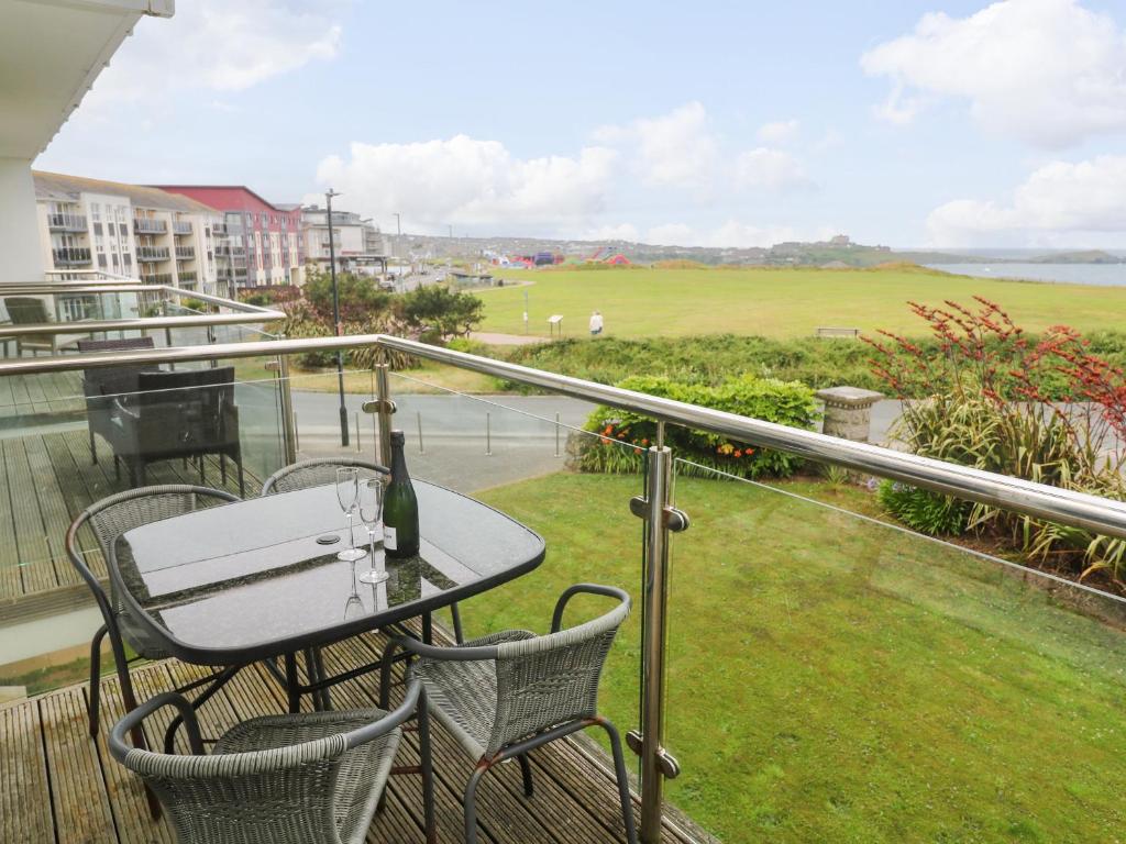 a balcony with a table and chairs and a field at Ocean Seven in Newquay