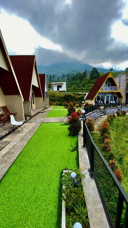 a garden with green grass next to a building at villa cabin vianda in Kejajar