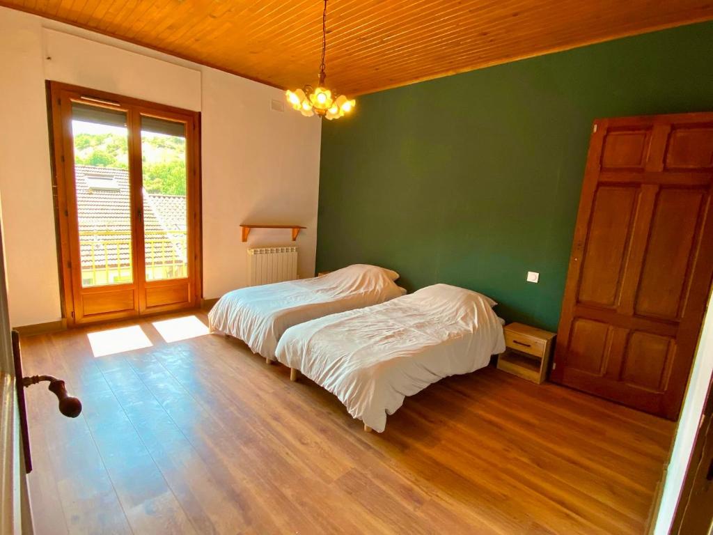 a bedroom with two beds and a green wall at Casa d'Eva in Pont-en-Royans