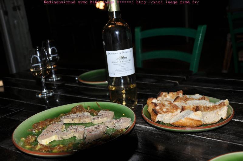 una mesa con dos platos de comida y una botella de vino en Domaine de Nidolères, en Tresserre