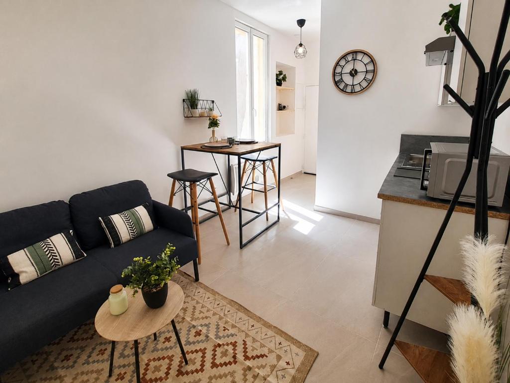 a living room with a couch and a table at Le Refuge de l'Écusson - T2 centre-ville, WIFI in Montpellier