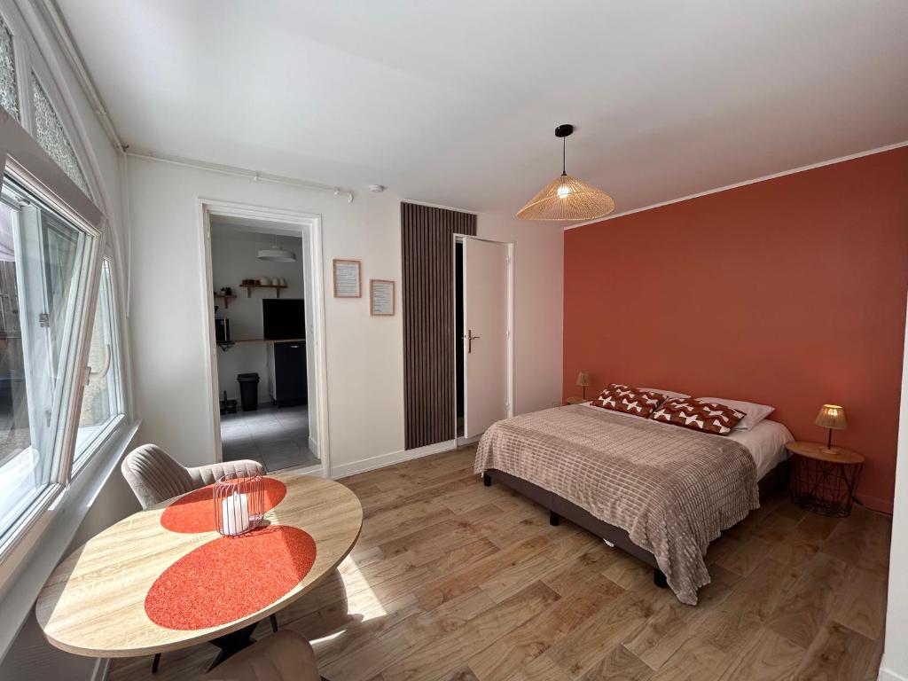 a bedroom with a bed and a table in it at Charmant studio avec terrasse in Fécamp