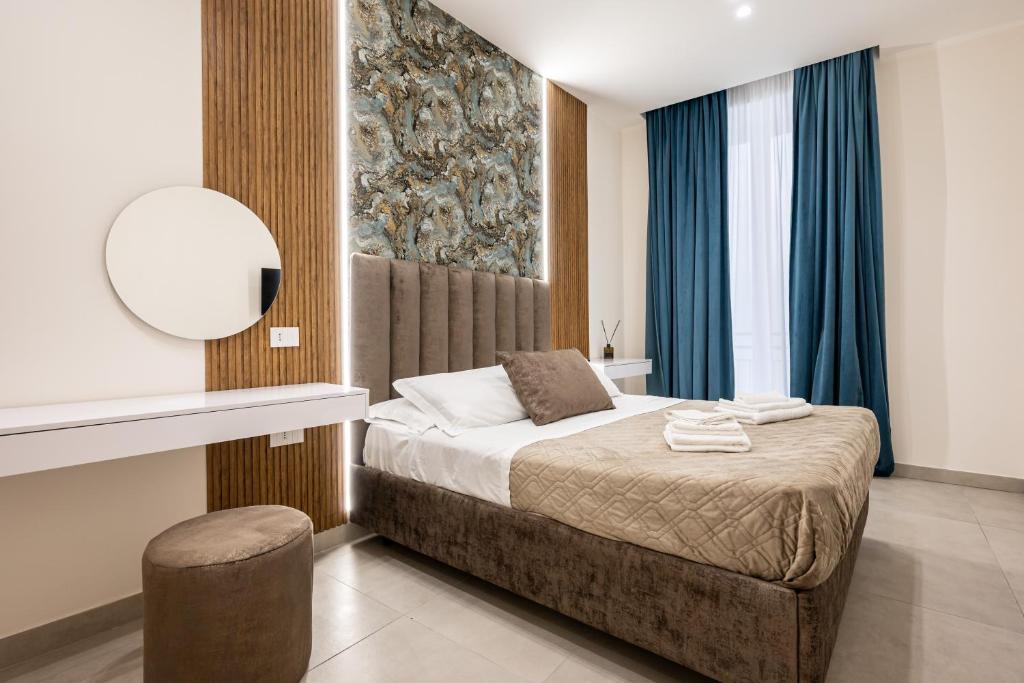 a bedroom with a bed with a mirror and blue curtains at Guest house terra mia a Toledo in Naples