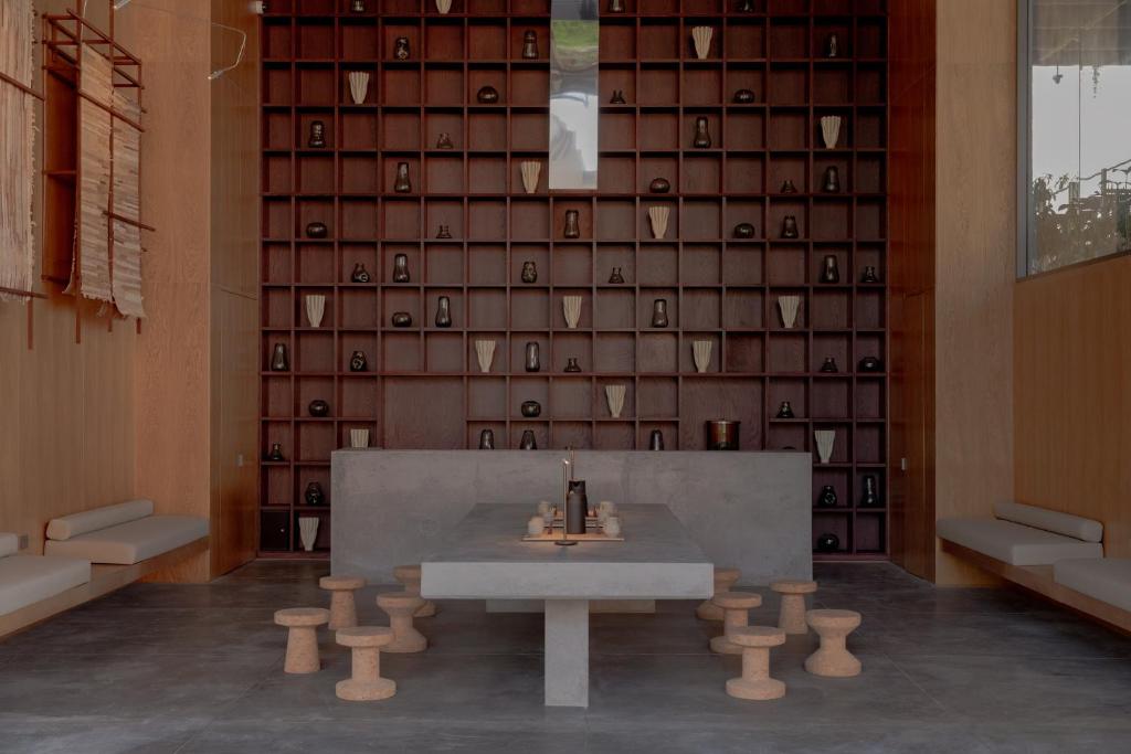 a table in a room with a wall of wine glasses at Wake Medellin, a Member of Design Hotels in Medellín