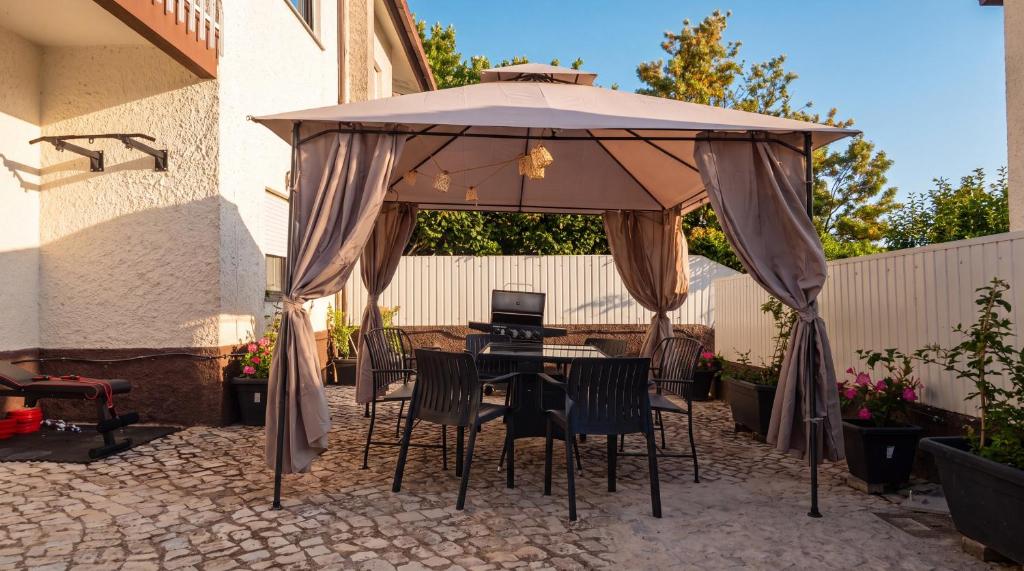 a table and chairs under an umbrella on a patio at 7Min to Uni Sé-Velha - AC - BBQ & Gym - Work Desk - 300MBs WiFi - Suite 4 in Coimbra