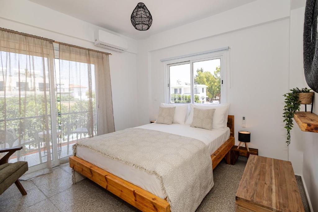 a bedroom with a bed and a large window at Olive Grove Apartments in Larnaca