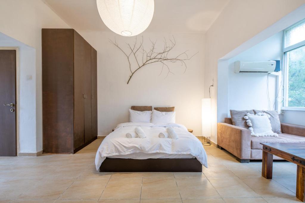 a bedroom with a large bed and a couch at Green Emerald in Haifa