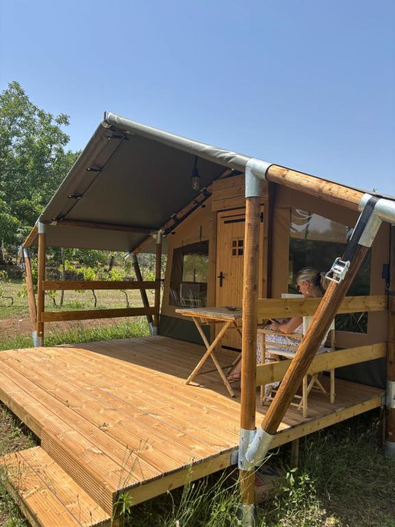 a man reading a newspaper in a wooden house at Vulture Glamping in Melfi