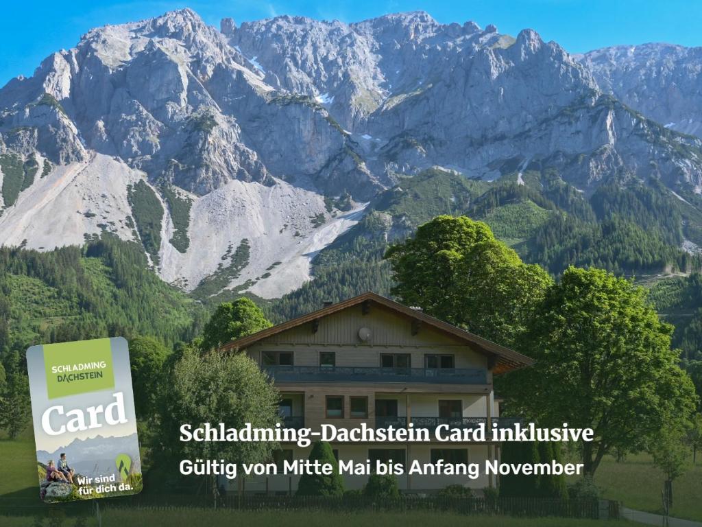 a building in front of a mountain range at Ferienwohnung Alpenecho in Ramsau am Dachstein