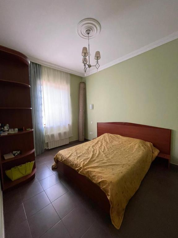 a bedroom with a large bed and a chandelier at JB Dubendi house in Baku