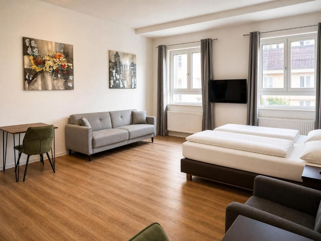 a bedroom with a bed and a couch and a table at TRUST Boardinghouse in Stuttgart