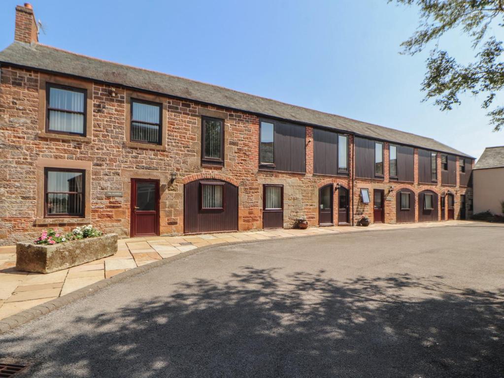 a brick building with a driveway in front of it at The Hayloft in Wigton