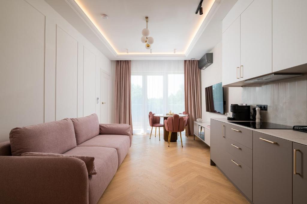 a living room with a couch and a kitchen with a table at Golf Park Rajszew in Rajszew