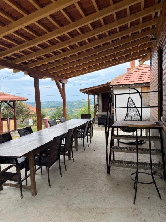 a long wooden table and chairs on a patio at Kod Svastike in Džepare