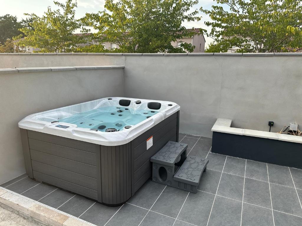 a hot tub sitting on the side of a building at Suites appartement 1 chambre & Spa in Montauban