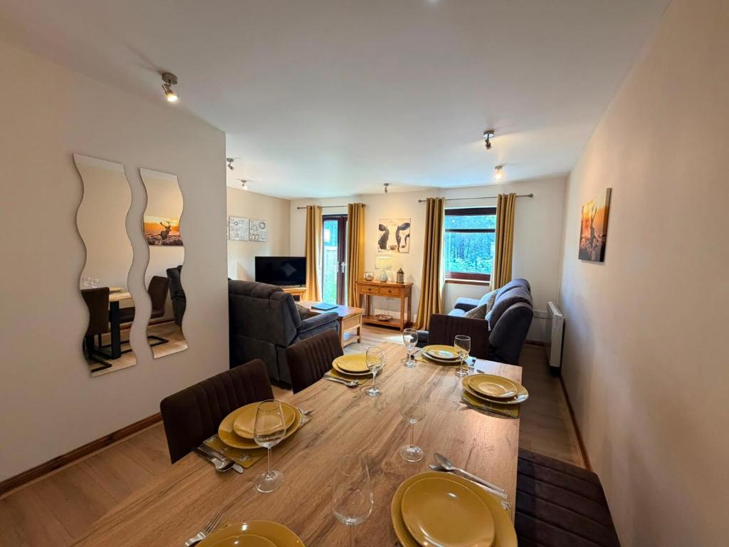 a living room with a dining room table with wine glasses at The Galleries No 3 in Spean Bridge