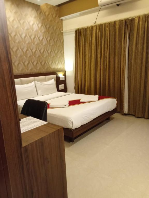 a hotel room with two beds and a mirror at Royal Indraprastha The Hotel in Bangalore
