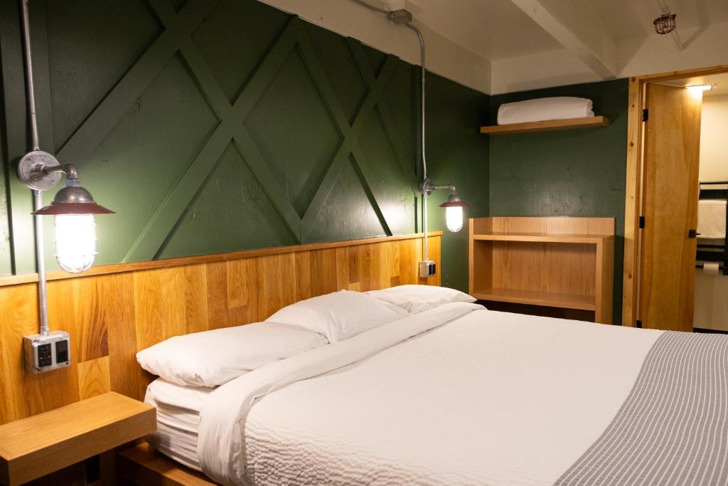 a bedroom with a large bed with a green wall at The Hostel in Teton Village