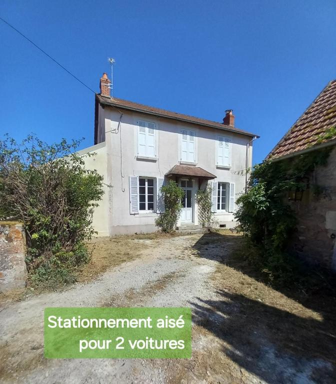 a white house with a dirt road in front of it at Gite de Chassigny in Avallon