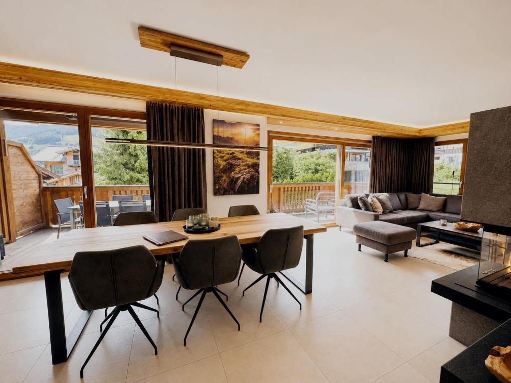 a living room with a wooden table and chairs at Mountain Lodge Leogang-Premium Apartment, Balkon, Bergblick, Kamin, Sauna in Leogang