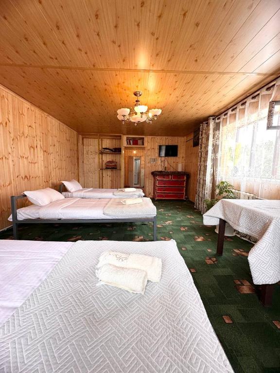 a large room with two beds and a table at NURDAN Guest House Barskoon in Barskoon
