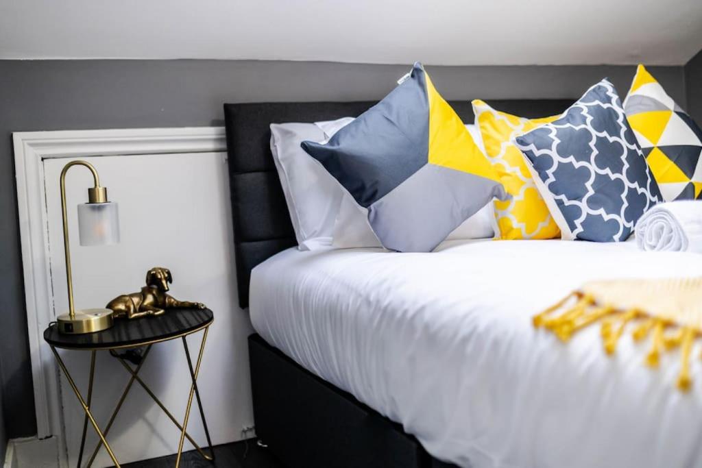 a bedroom with a bed with colorful pillows at Quiet Top-Floor Retreat -Modern Studio for 2 - Islington in London