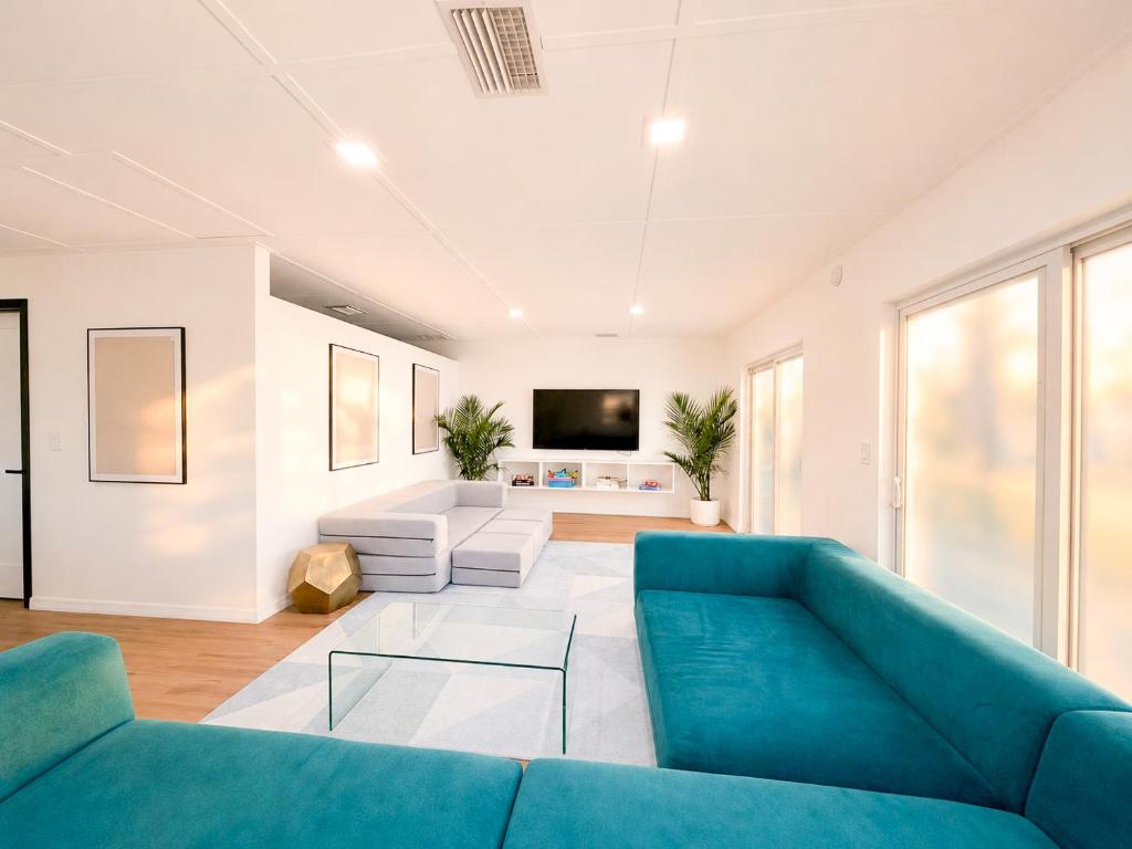 a living room with a blue couch and a tv at Tropical Luxe Villa-Near Airport, Minutes to Lido key beach, Downtown and Dining in Sarasota