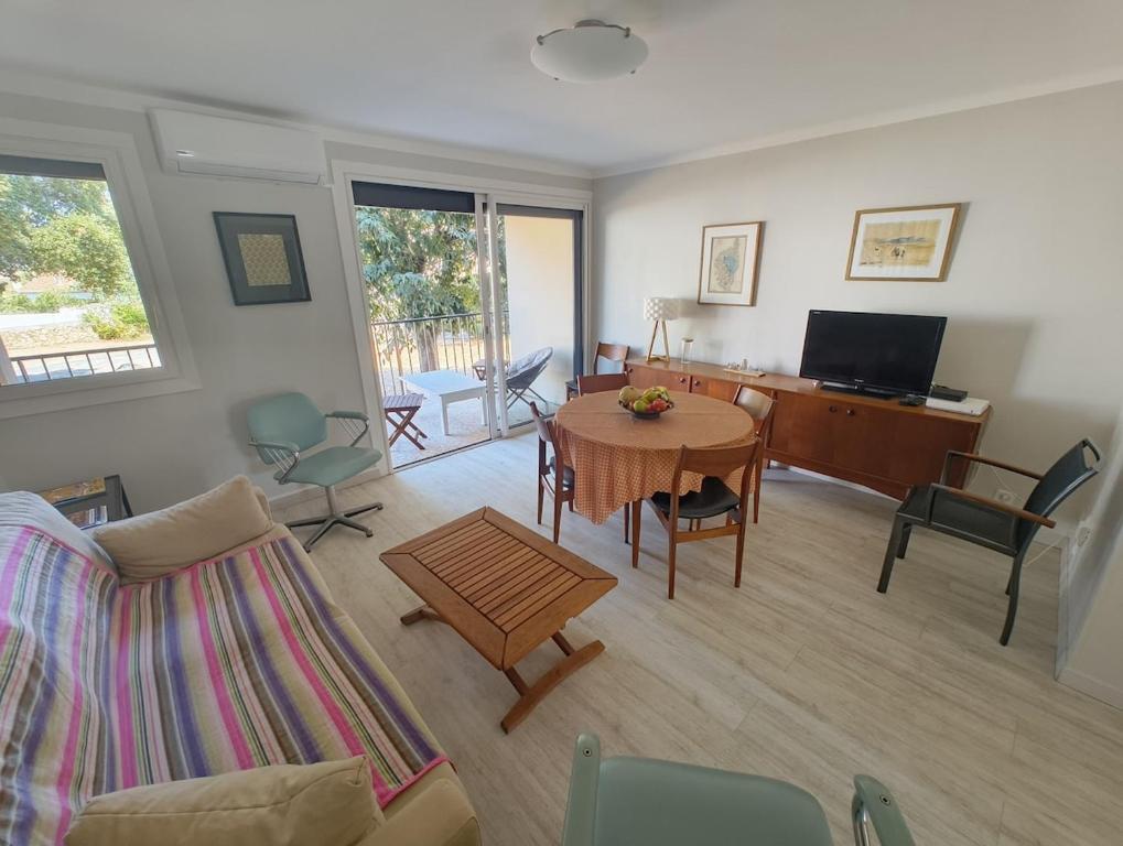 a living room with a table and a couch at T4 proche de la plage & du centre in LʼÎle-Rousse