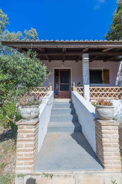 a house with stairs leading to the front door at Zanteva-Cottages in Vasilikos