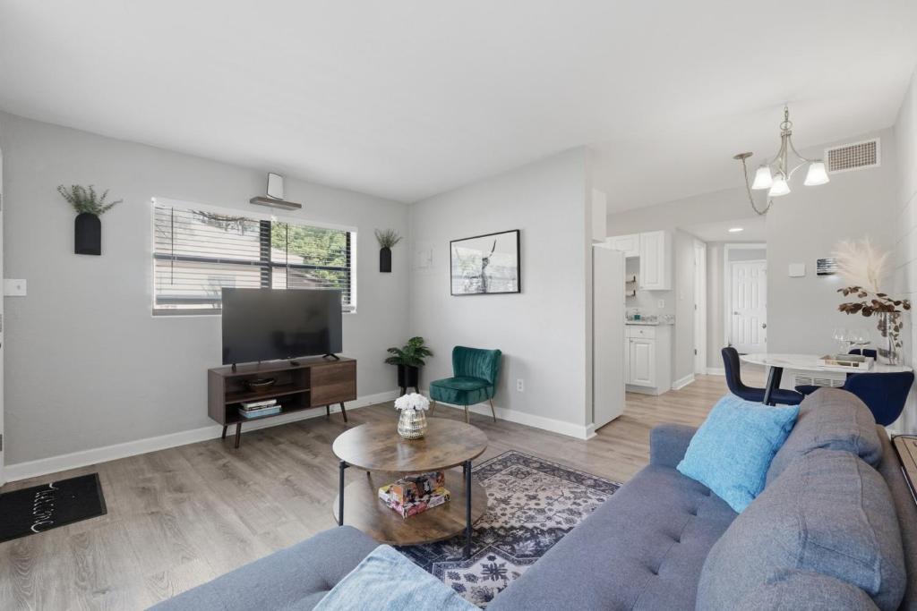 a living room with a blue couch and a table at Amazing 2BR Queen 8mins SODO & 4mins ORMC in Orlando