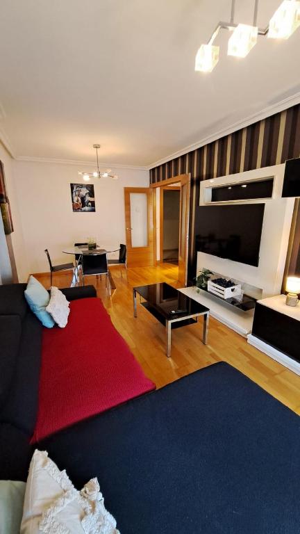 a living room with a couch and a red rug at LUMARE LUANCO - A 5 min de la playa a pie - Parking incluido in Luanco