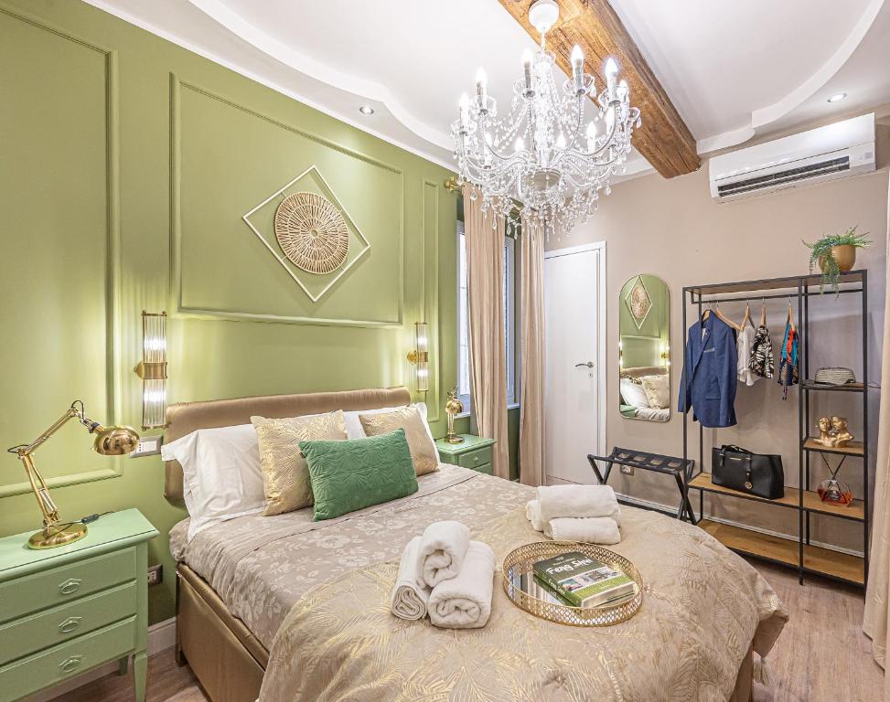 a green bedroom with a bed with towels on it at MInerva Pantheon Suites in Rome
